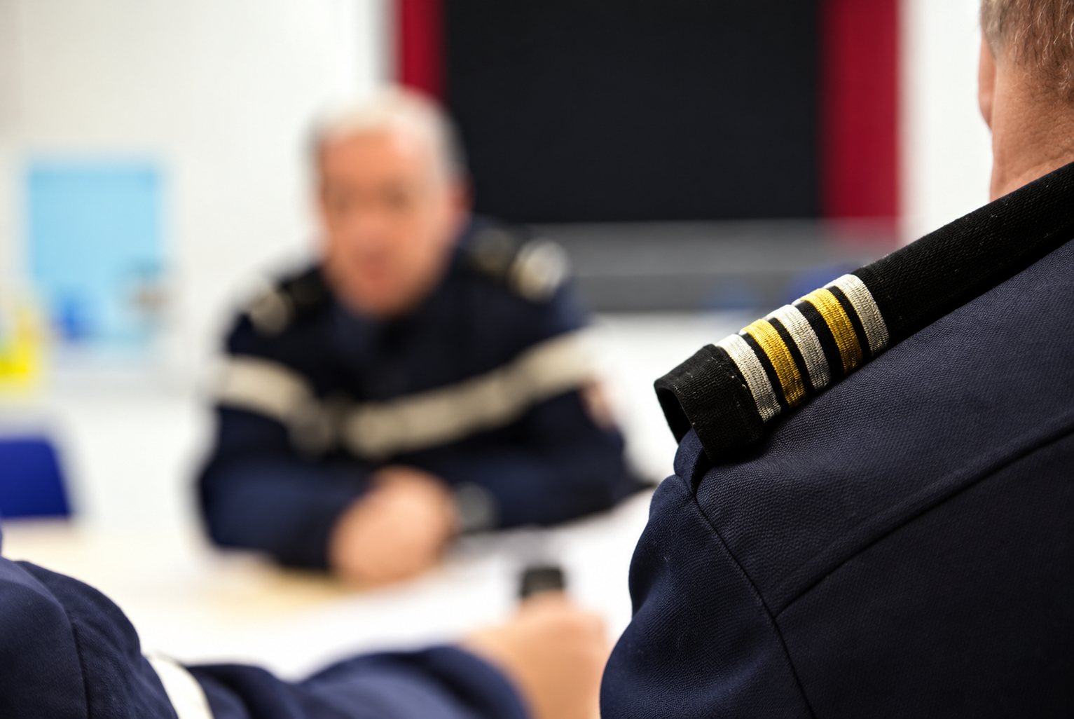 Officier de sapeurs-pompiers en arrière-plan flou, galons dorés au premier plan